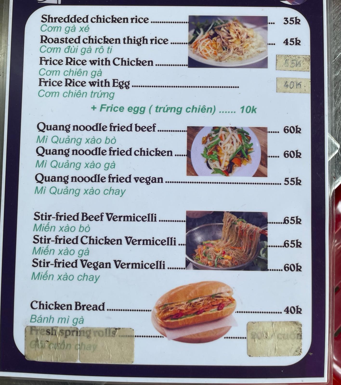 A local restaurant menu board listing rice and noodle dishes in Vietnamese and English