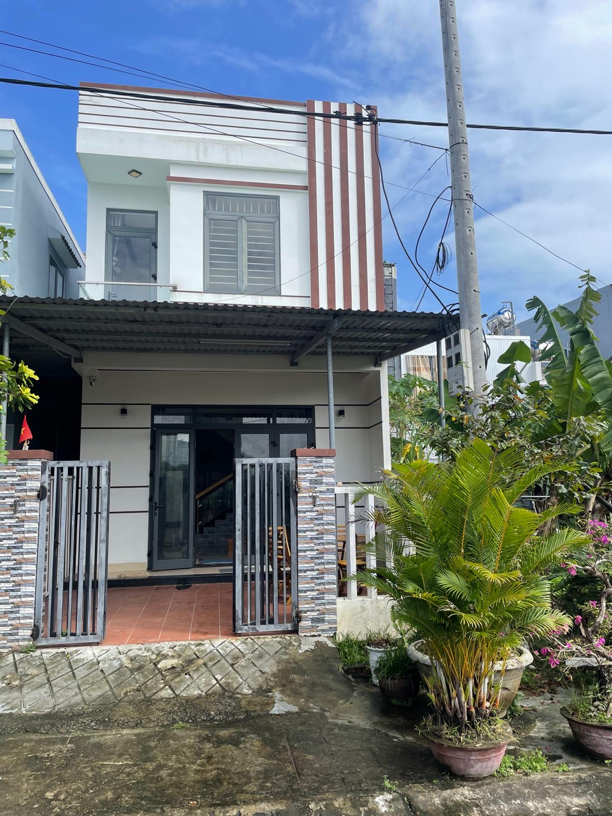 A modest two-storey rental house with a gated courtyard entrance