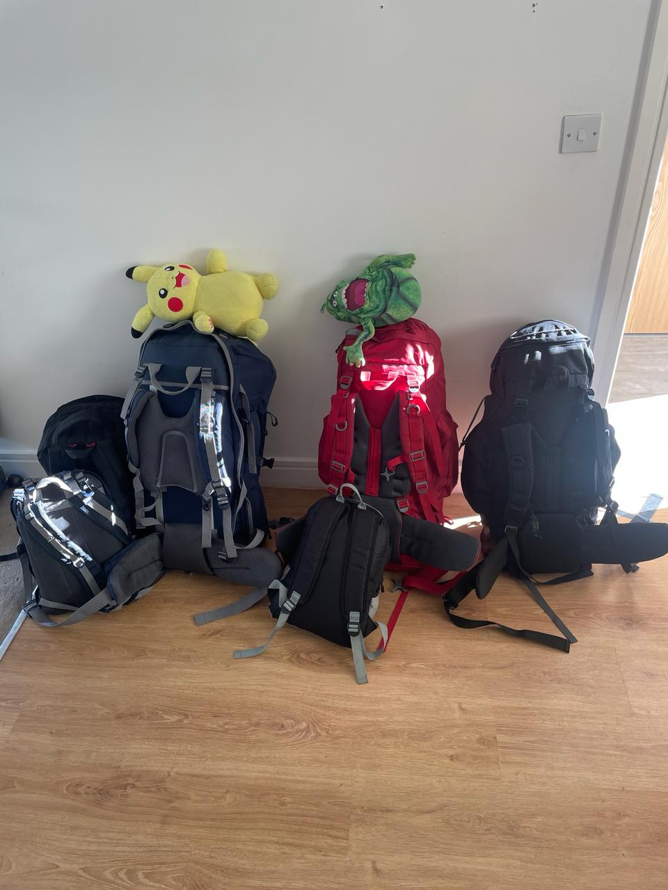 Four backpacks ready to go — Pikachu perched on top
