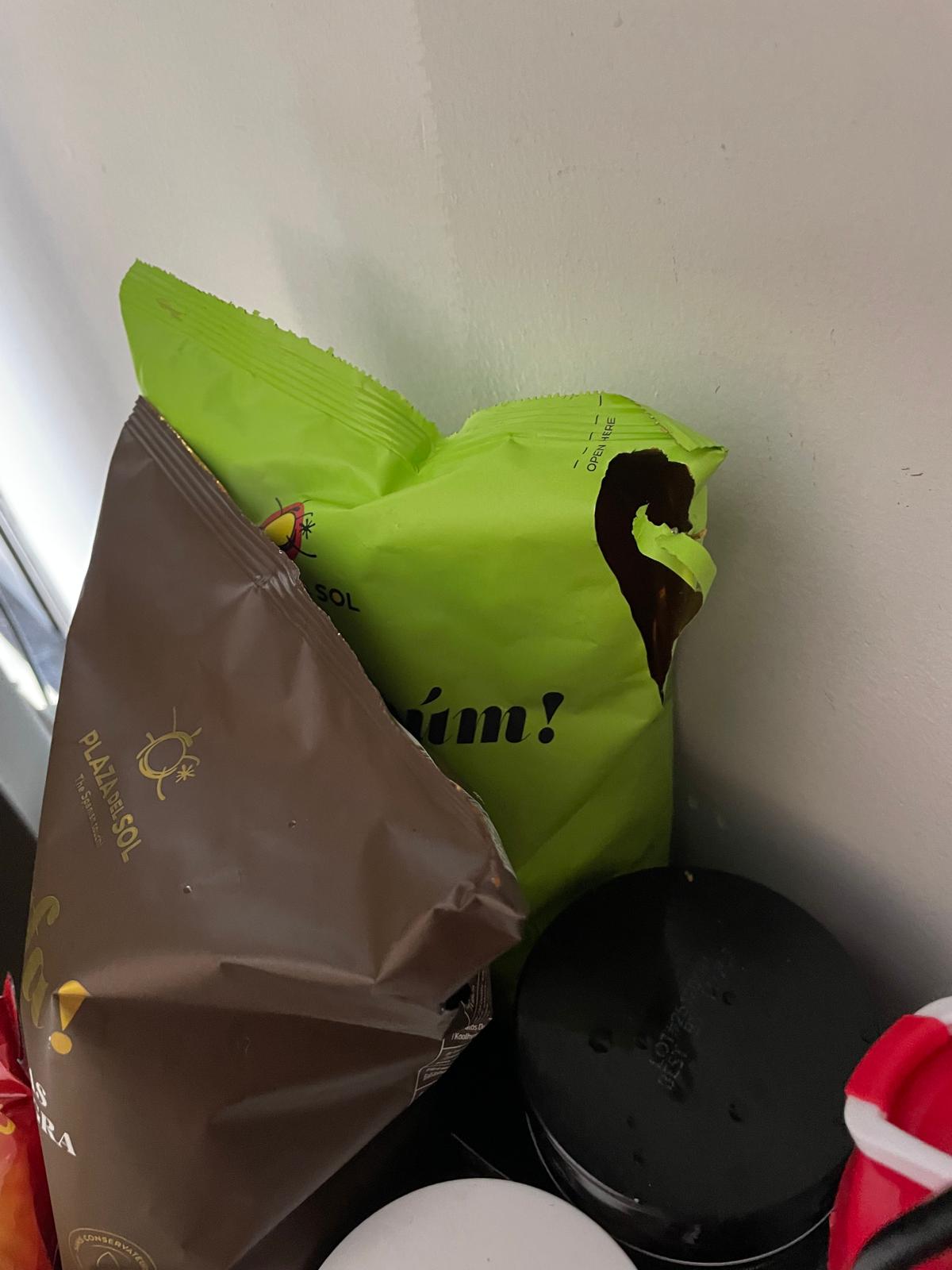 A green snack packet with a gnawed hole torn through its corner