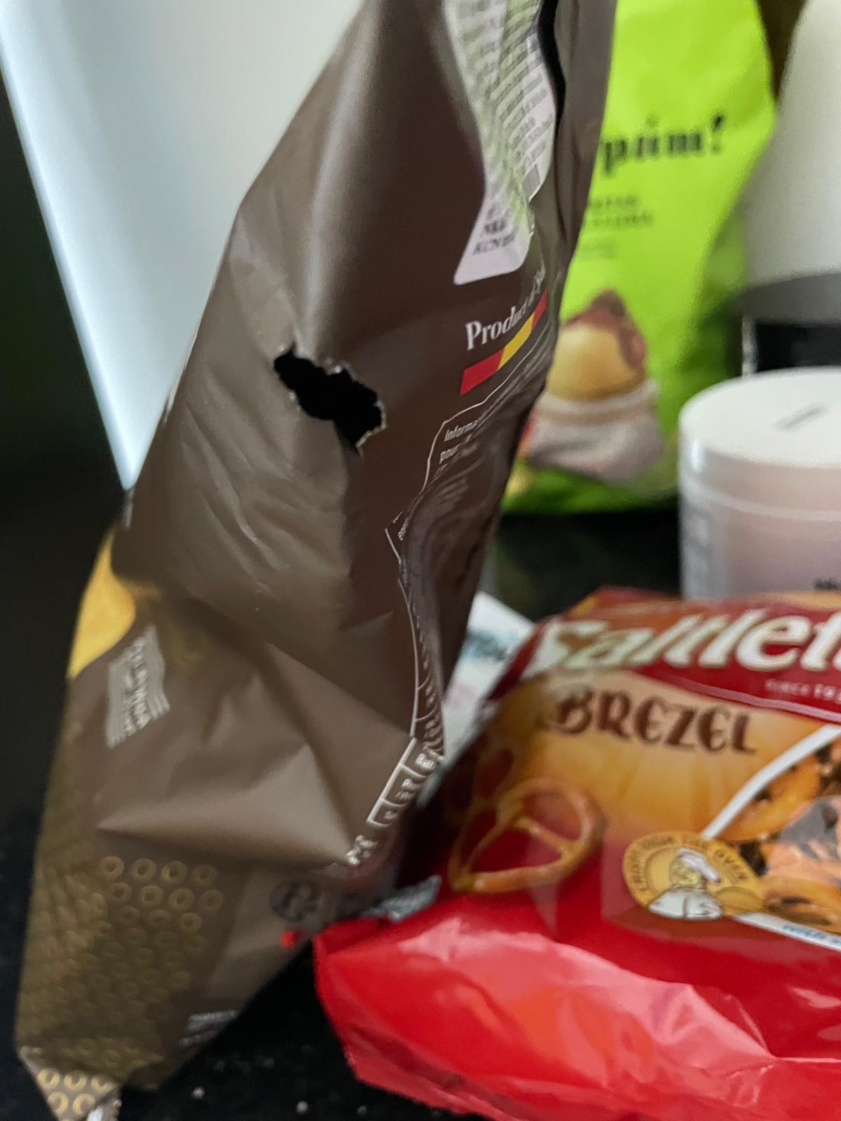 A brown snack packet with a gnawed hole close up